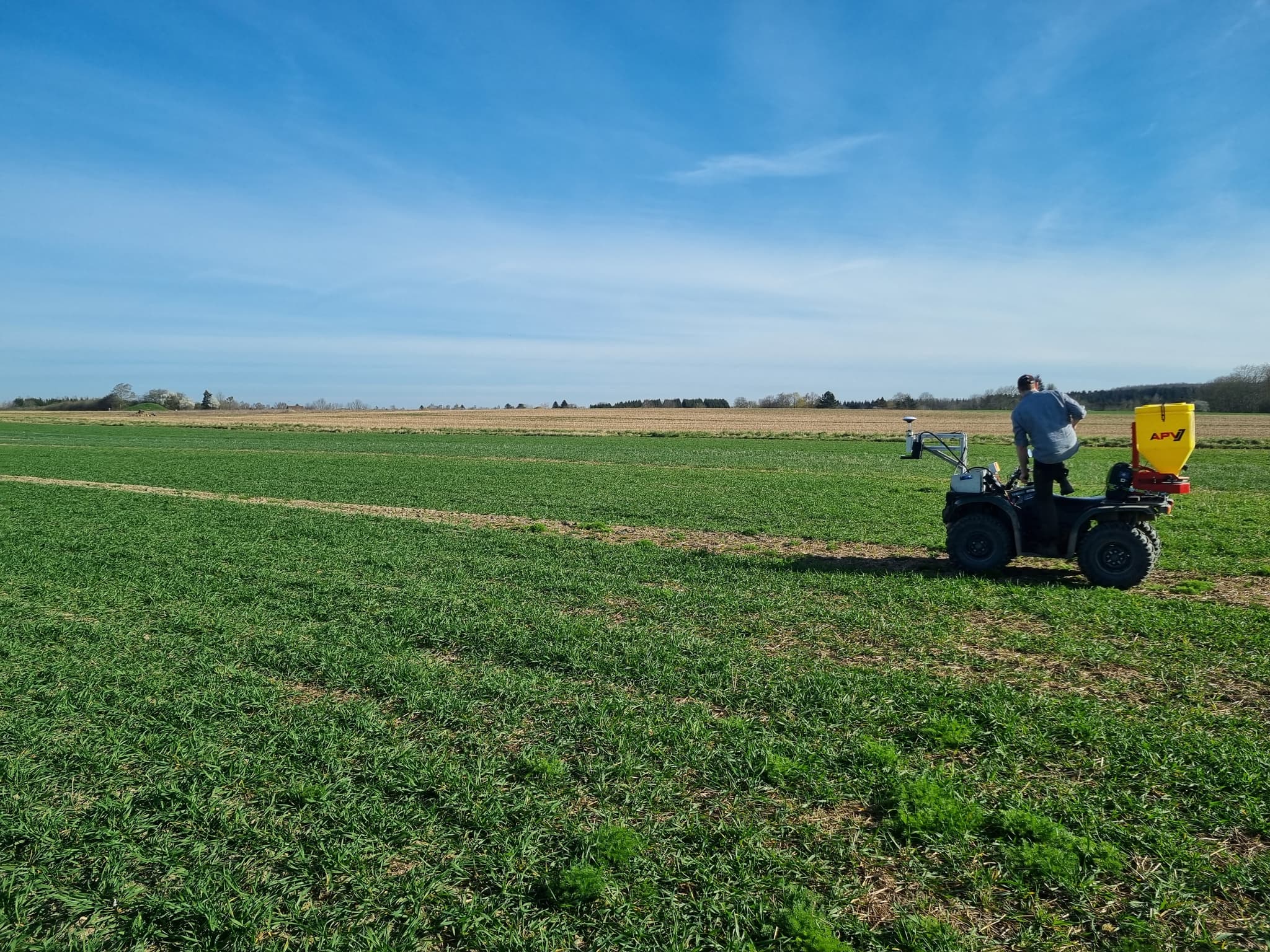 ATV-mounted spray equipment operating in a green paddock
