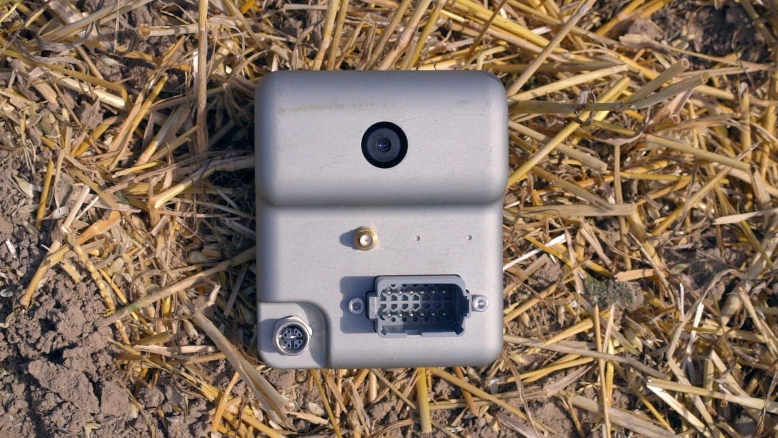 An OWL camera unit lying in wheat stubble, seen from above