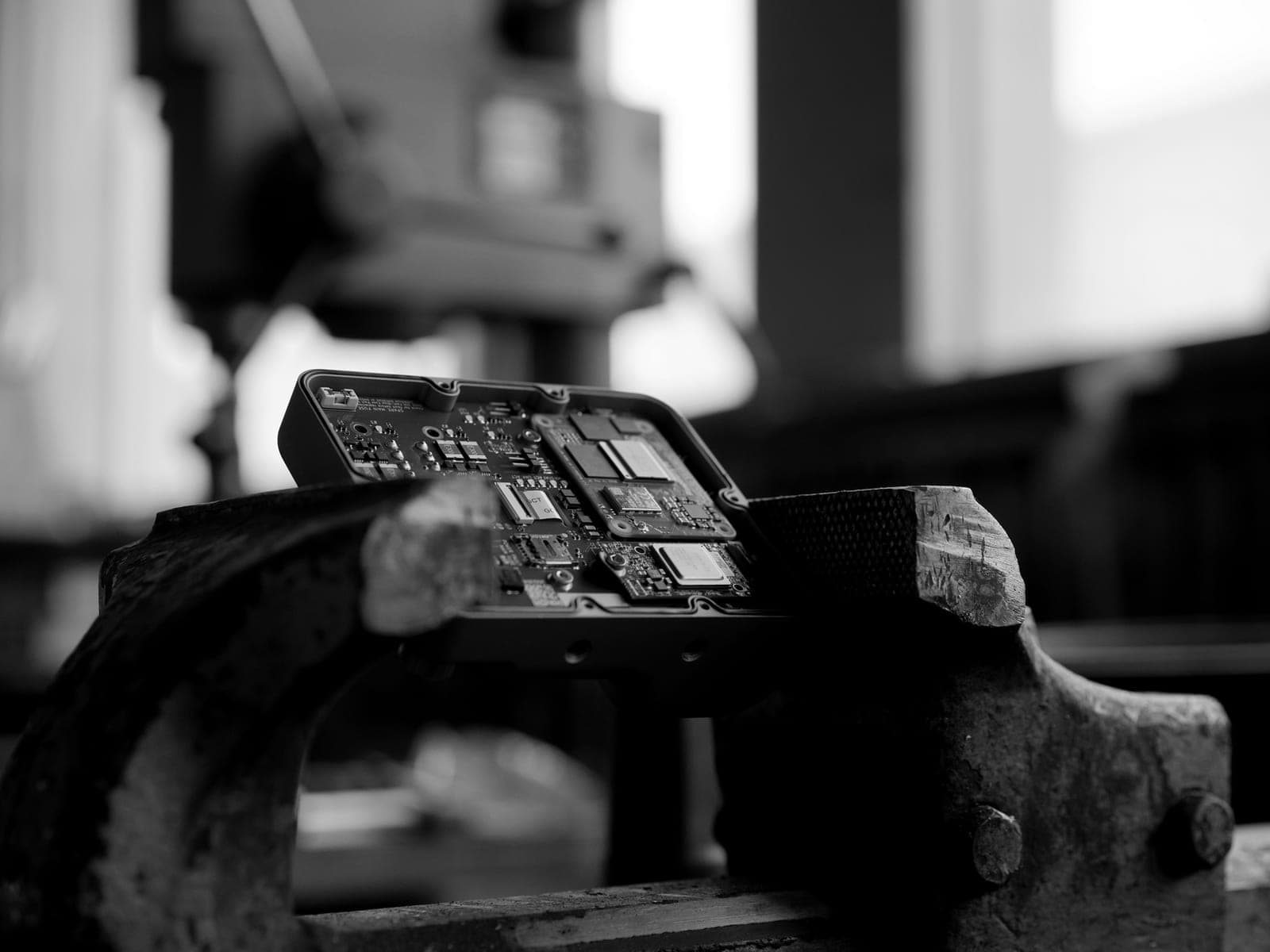 OWL carrier board held in a workshop vise, black and white
